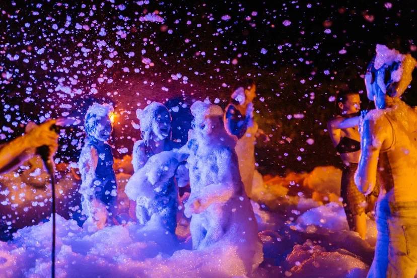 A foam party after dark, lit like a music video — photo 3